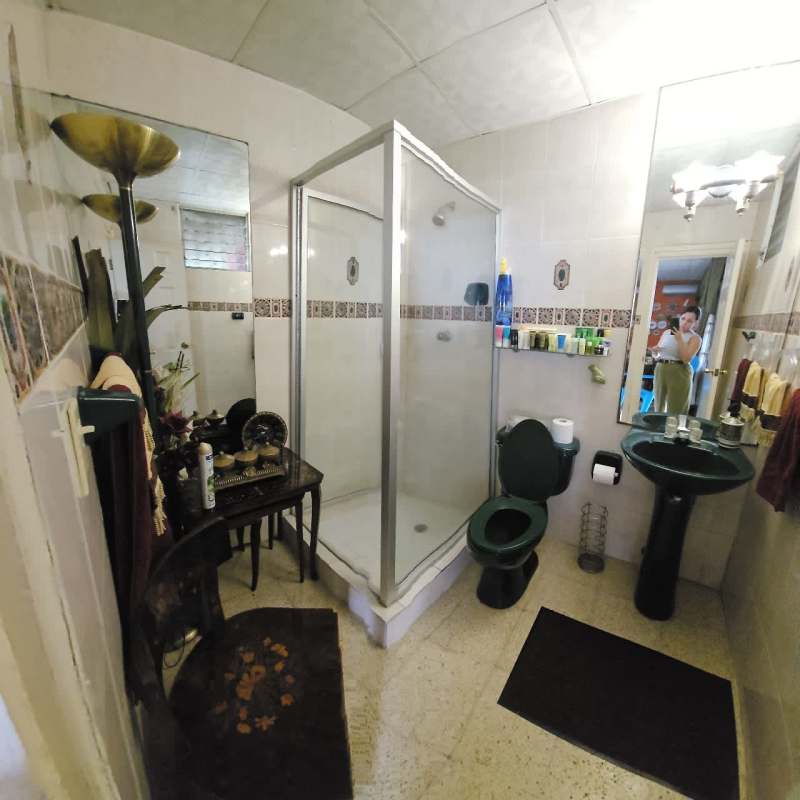 Bathroom with glass shower, mirrors, sink, green fixtures at Villa Lucre house for sale Panama