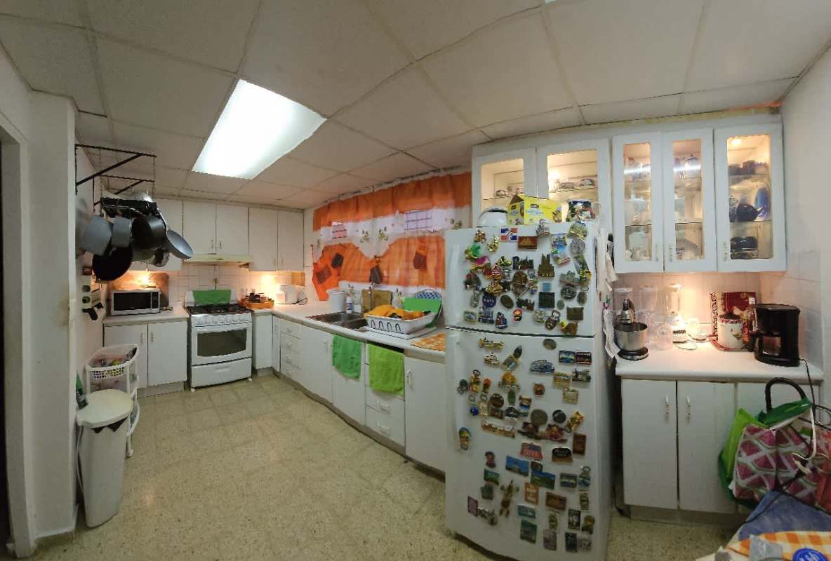 Kitchen with white cabinets, refrigerator, gas stove, microwave, and double sink at Villa Lucre Panama