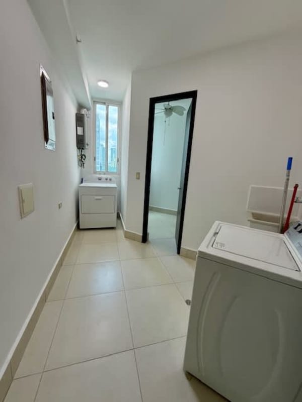 Open kitchen with island and corner windows with ocean and city views PH Castellammare Costa del Este Panama