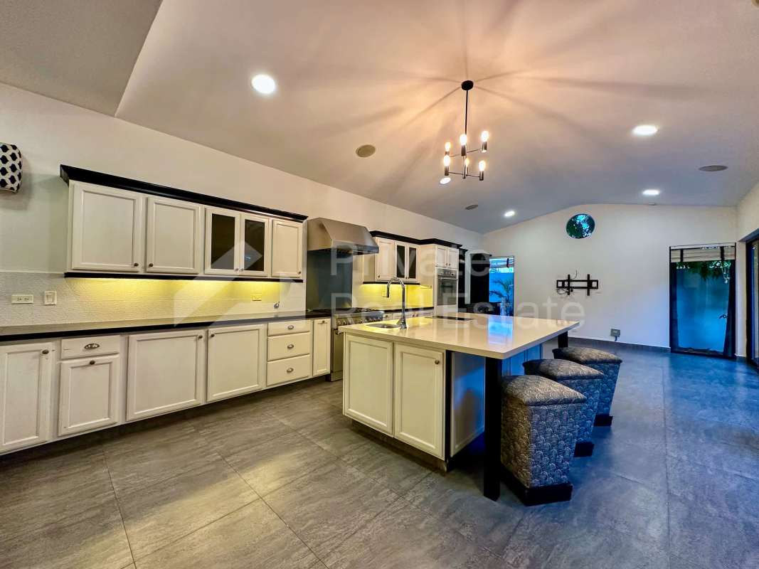 Modern floating marble staircase with glass railing and chandelier in PH Antigua Costa del Este Panama