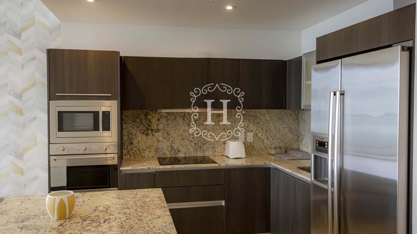 Modern kitchen with granite countertops, stainless steel appliances, and dining area at The Ocean Club Panama