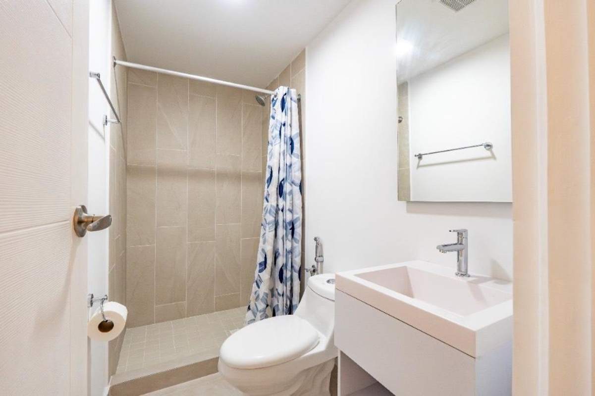 Modern bathroom with neutral tiles, sink and shower in Panama Viejo Residences apartment for rent