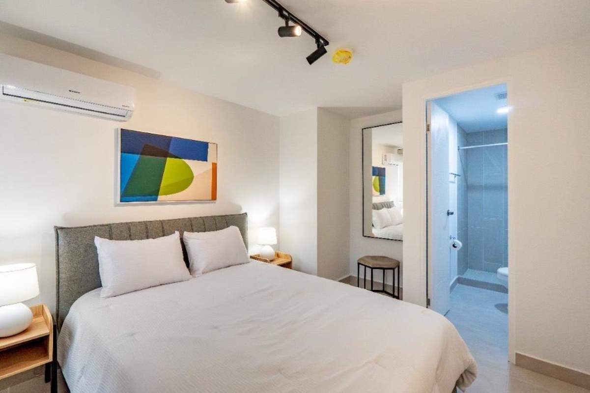 Modern bedroom with ensuite bathroom, wall art, split AC in Panama Viejo Residences for rent