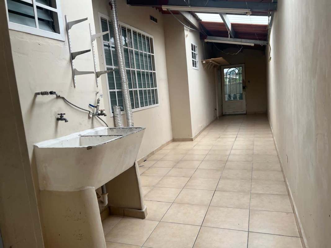 Functional covered laundry space with sink window grilles in Panama City Brisas del Golf