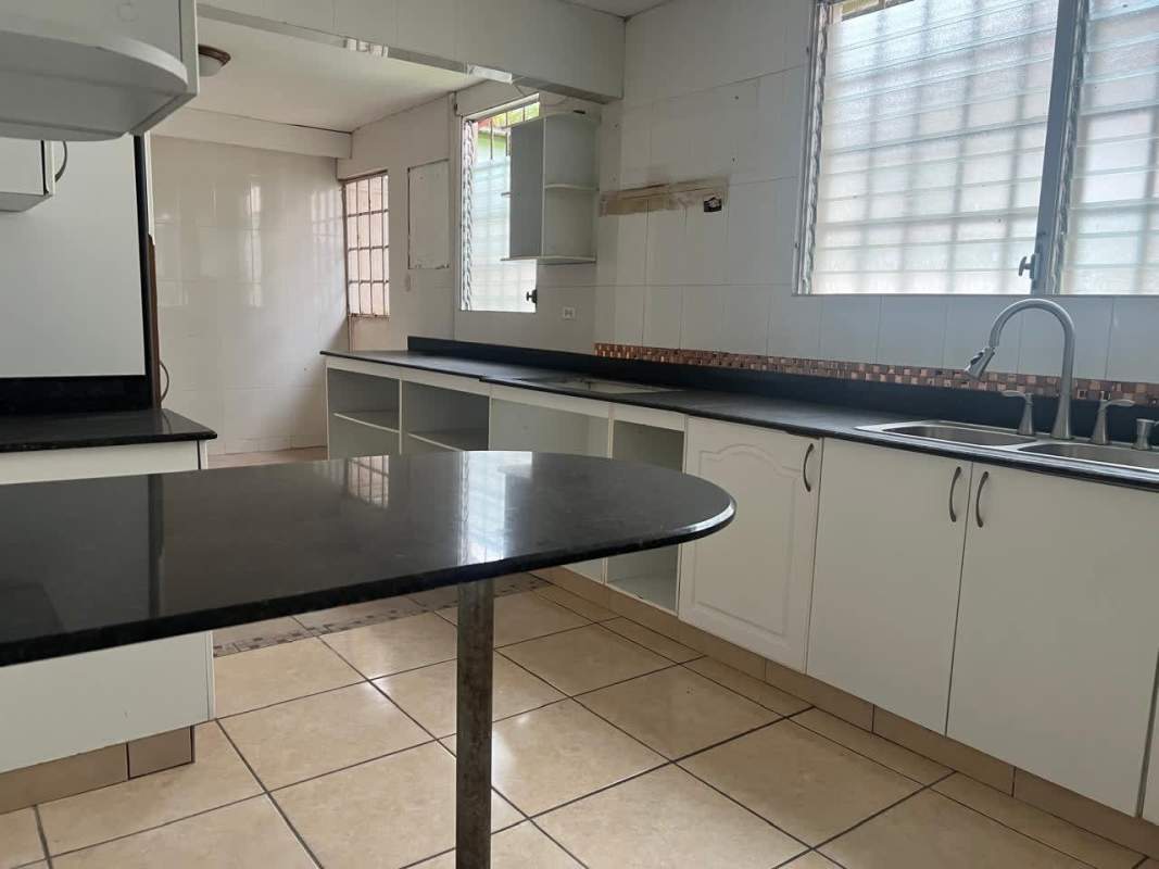 Modern kitchen with granite counters, backsplash, and breakfast bar in Brisas del Golf Panama