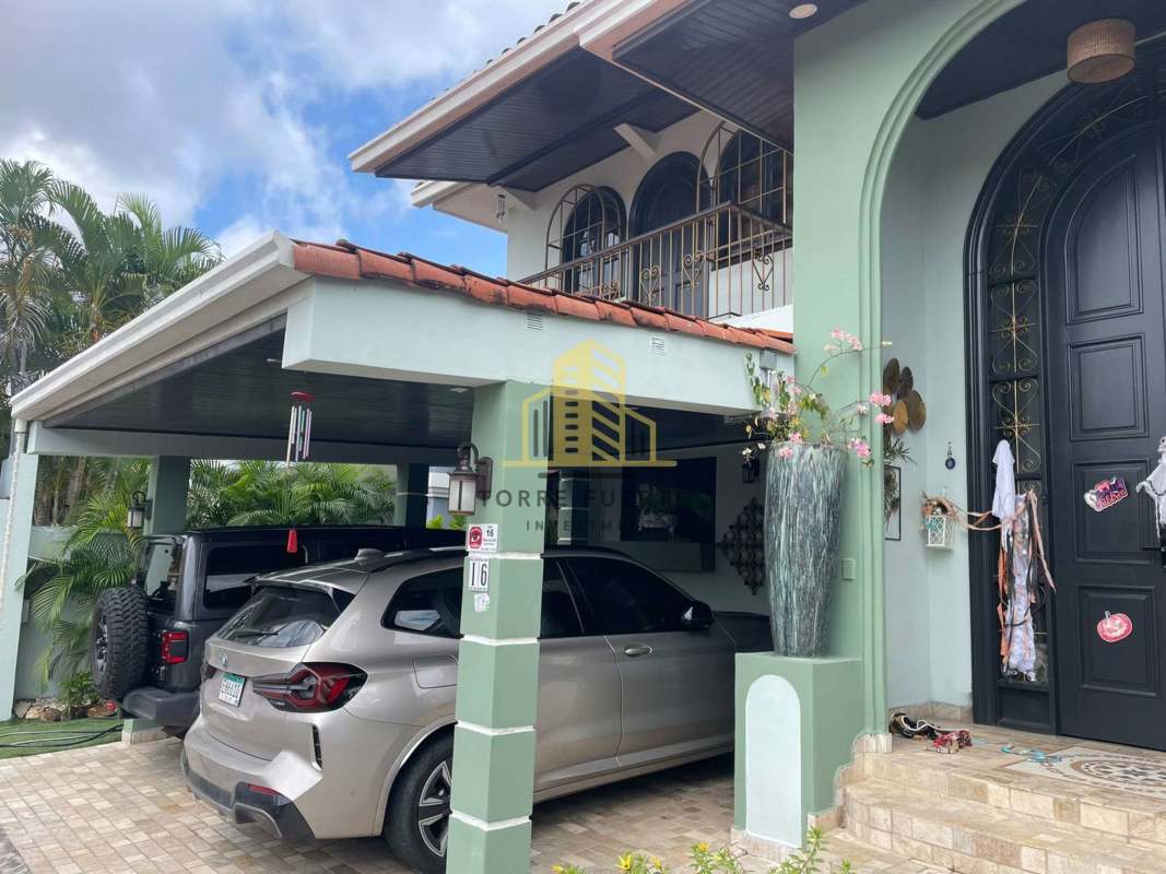 Interior staircase with ornate railing and chandelier in Brisas del Golf house Panama