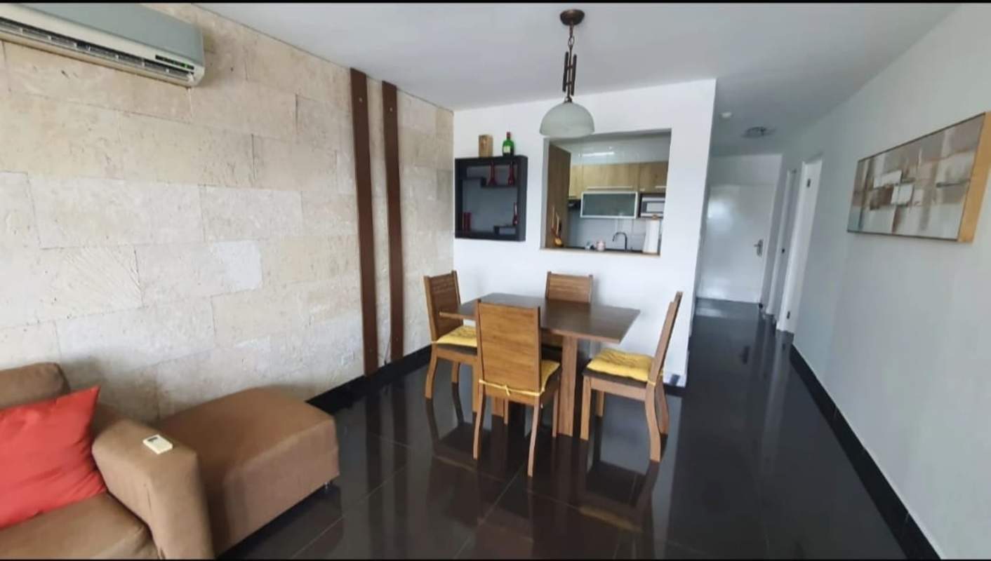 Dining area with wood table, accent wall and open kitchen view PH Majestic Garden Panama