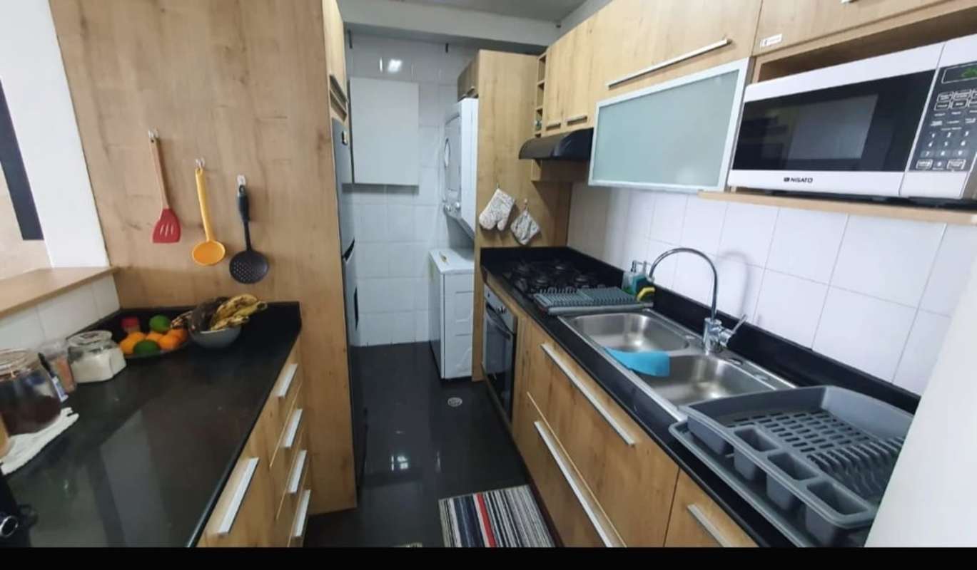 Modern kitchen with granite countertops, wooden cabinets, laundry area PH Majestic Garden Panama