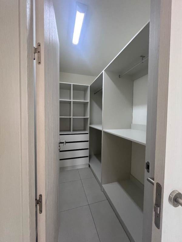 Spacious walk-in closet with custom white shelving in PH Coco Place Coco del Mar Panama City