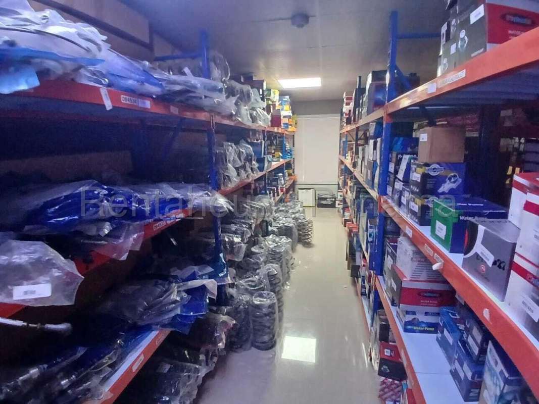 Organized metal shelving filled with automotive spare parts inventory inside warehouse