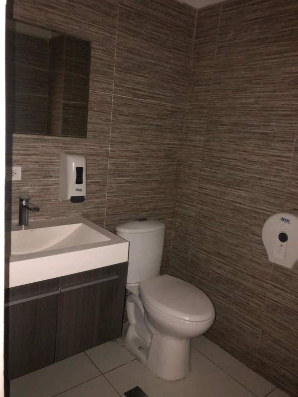 Compact bathroom sink toilet mirror tile walls in commercial rental Obarrio