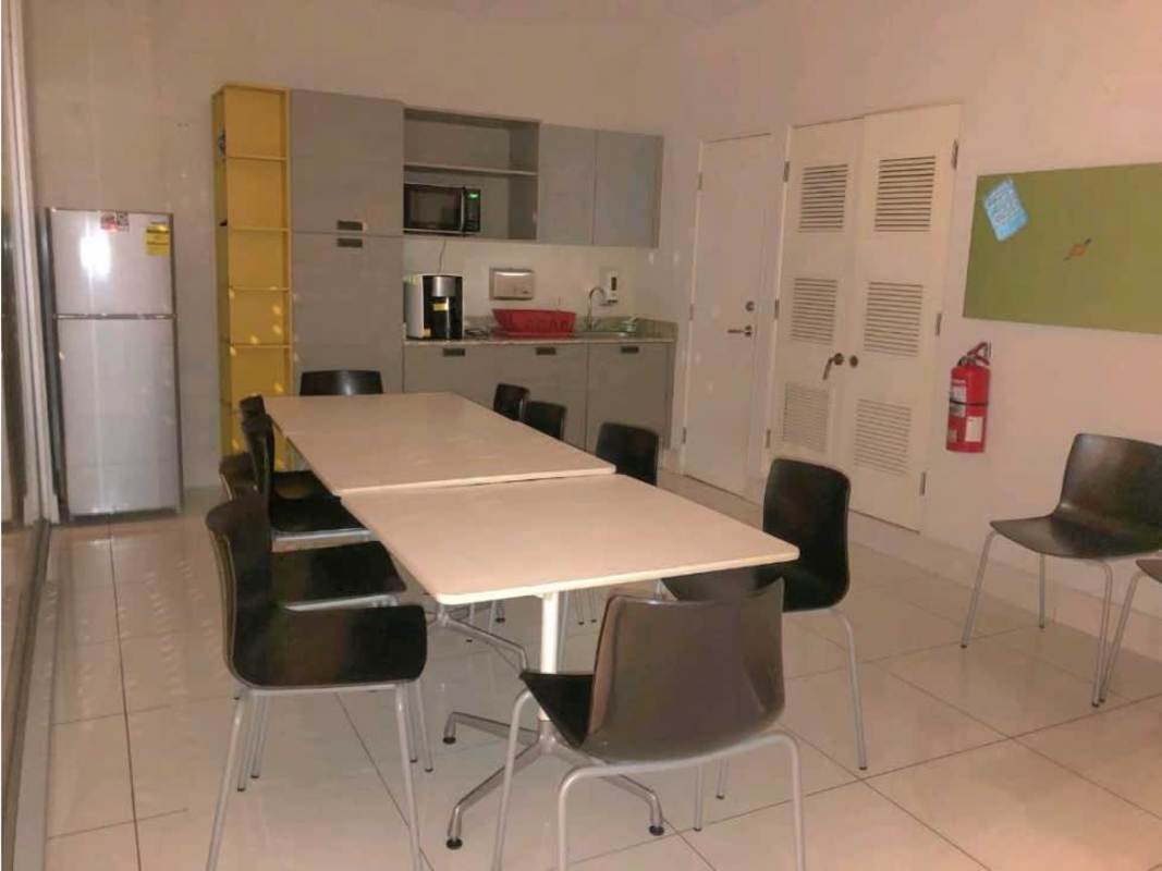 Modern kitchenette with dining tables and yellow shelves in commercial plaza in Panama City