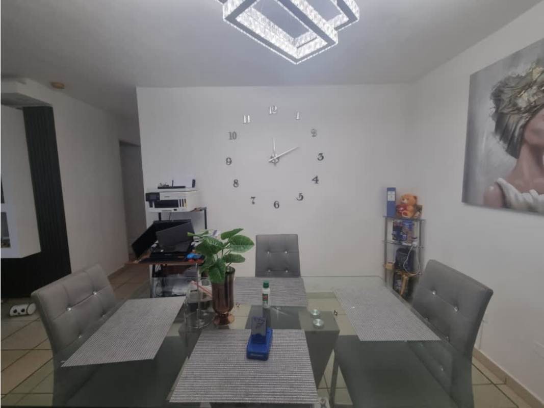 Dining area with glass table, wall clock, modern lighting at PH Vista Esmeralda Panama City