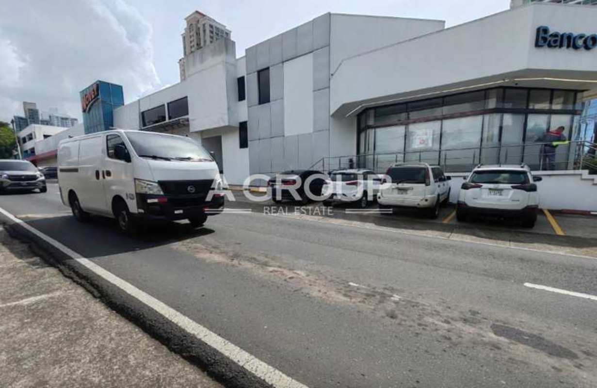 Modern commercial building with large glass windows and parking in Panama City