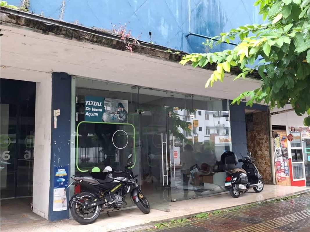 Exterior photo of storefront with glass facade motorbikes and street in Panama City
