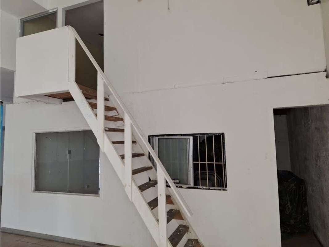 Warehouse interior with wood staircase leading to loft Rio Abajo Panama industrial space