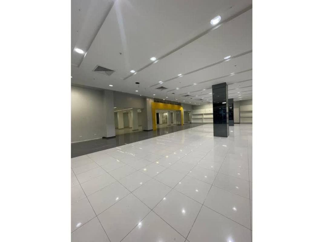 Retail store space with white tiles, recessed lighting and accent color wall inside Los Andes Mall Panama