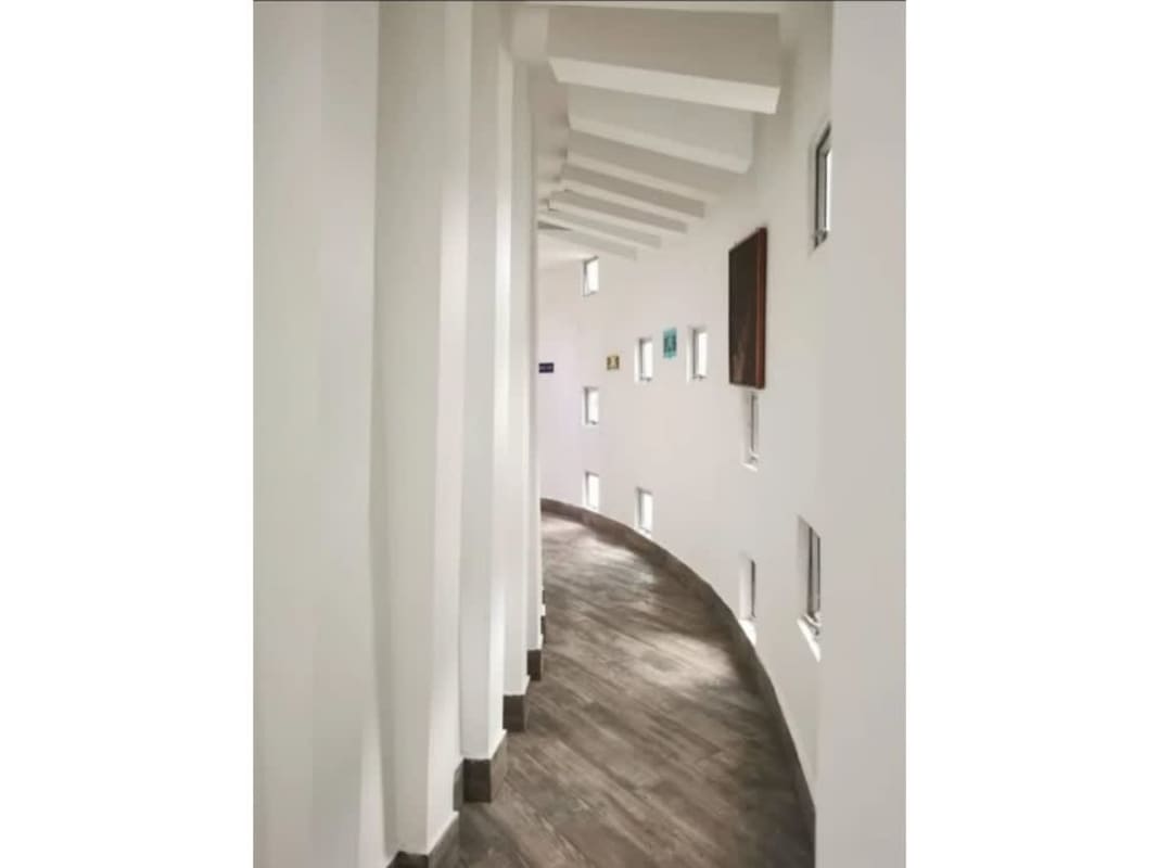 Curved modern corridor with windows and wood floors inside commercial building Costa del Este Panama