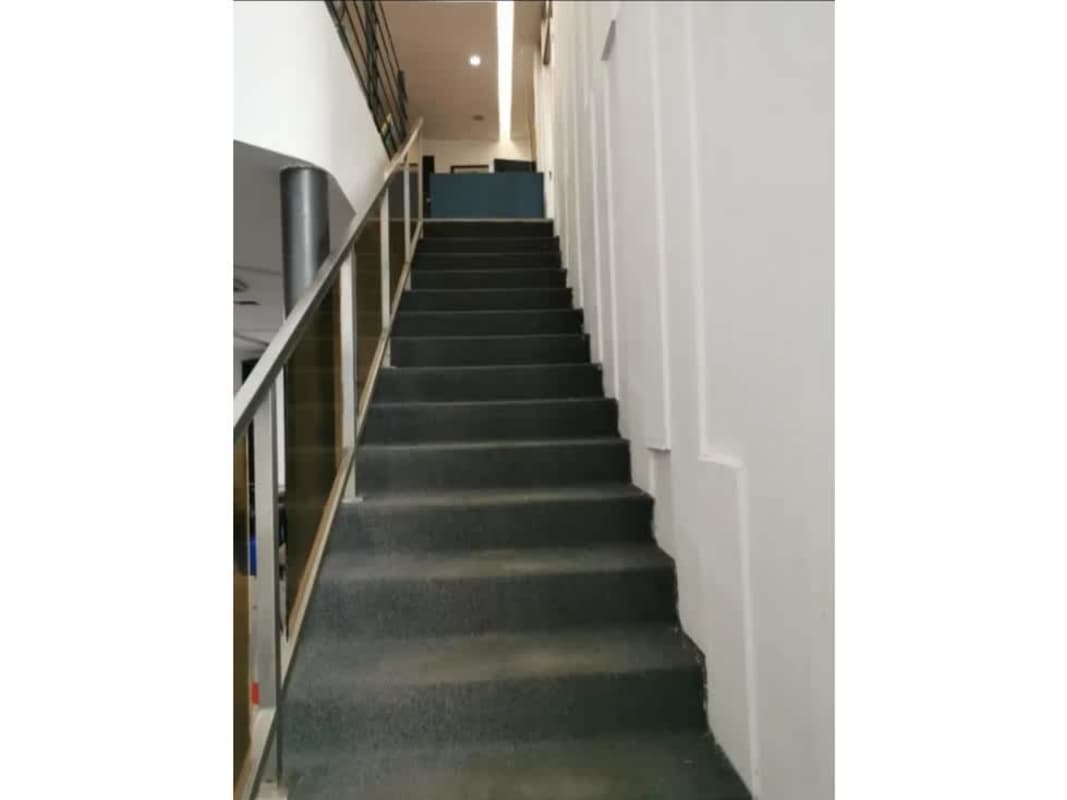 Minimalist staircase with metal rail glass panels and carpet in Costa del Este Panama commercial property