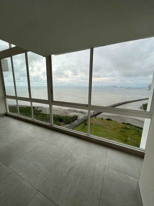 Modern double-height living room with floor-to-ceiling ocean view windows in PH Asia Penthouse Costa del Este