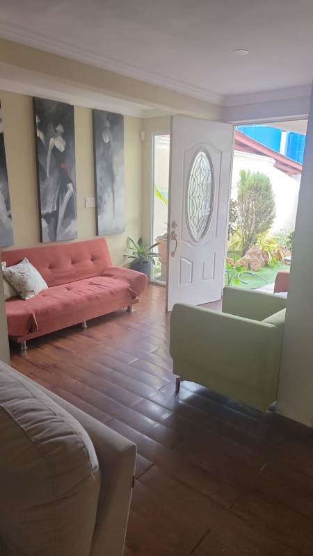 Living room with wood floors, art, natural lighting and glass doors in house for sale Panama