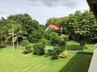 Fenced residential development lot with lawn and trees for sale in Coronado Panama