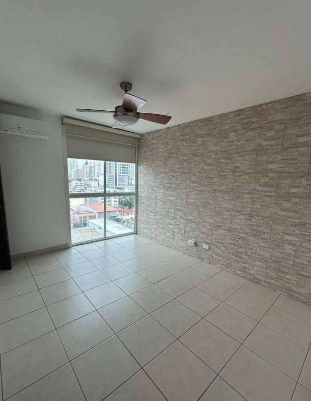 Bedroom featuring stone accent wall, ceiling fan, AC, city skyline view at PH Concept San Francisco Panama