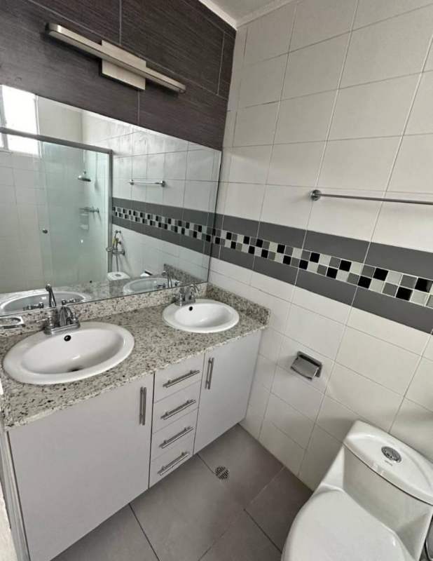 Modern bathroom with double granite sink, glass shower enclosure, large mirror in PH Concept Panama City