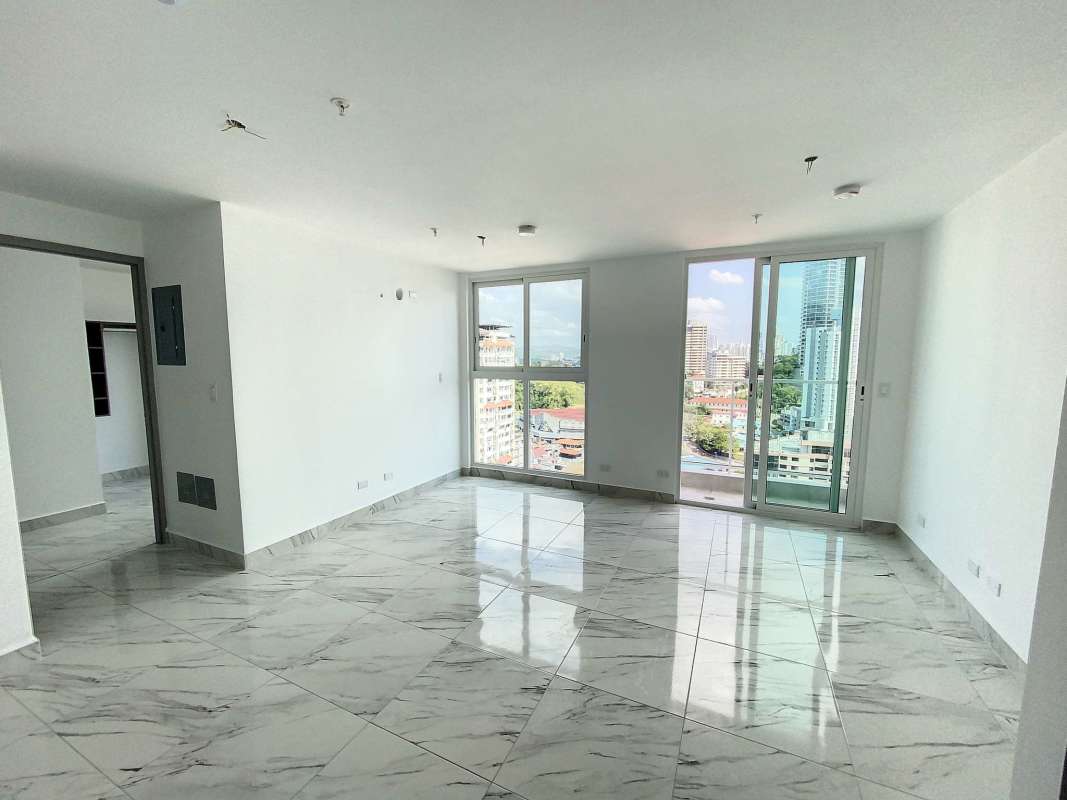 Modern apartment living room with large windows and skyline view at PH Botánico