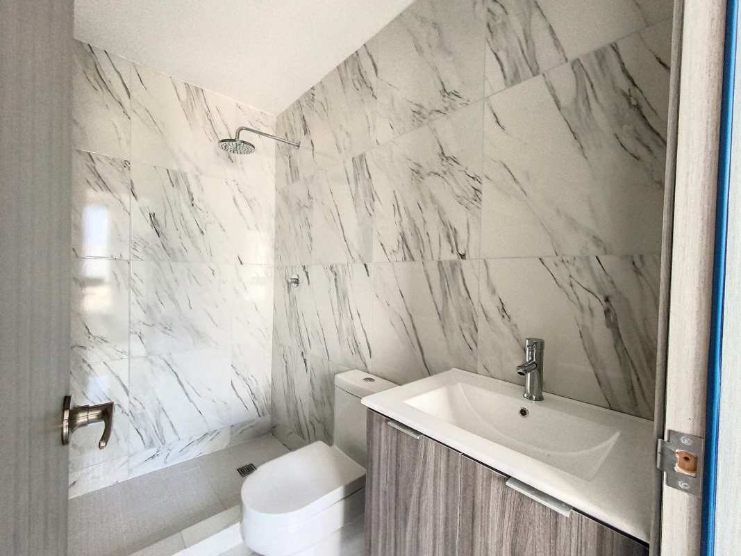 Bathroom with marble wall tiles and walk-in shower at PH Botánico
