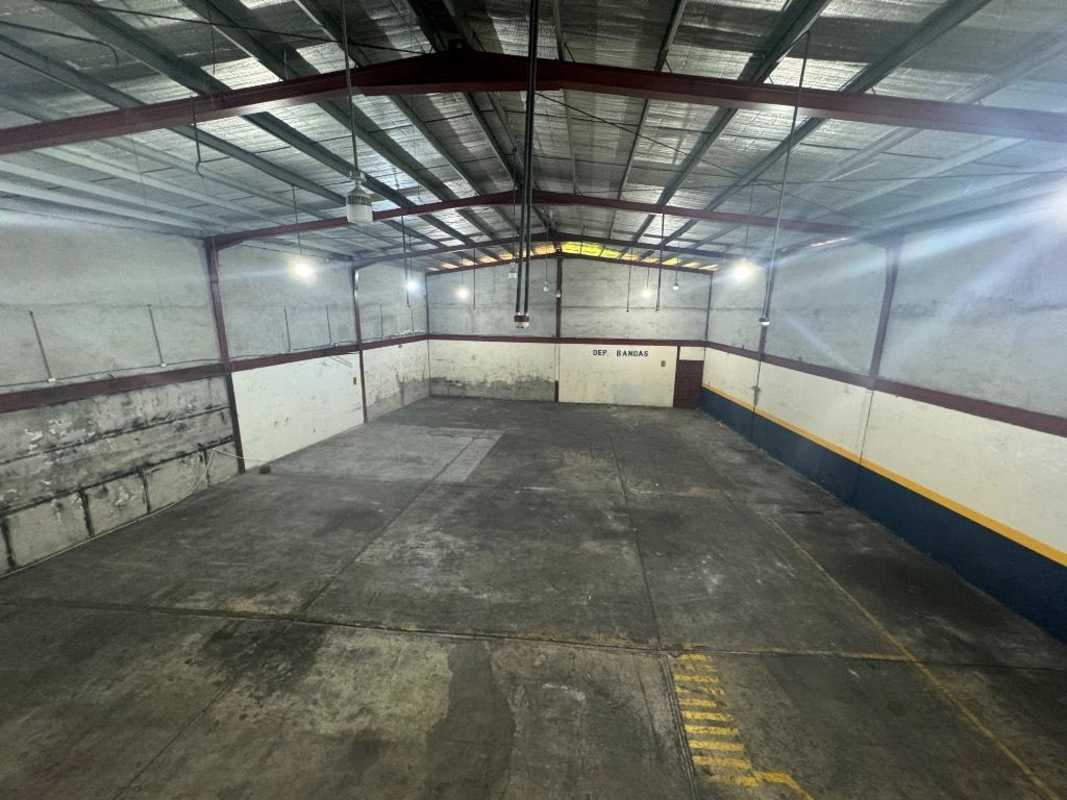 Interior of industrial warehouse with metal roof, exposed beams, concrete floor and large open space in Pueblo Nuevo Panama
