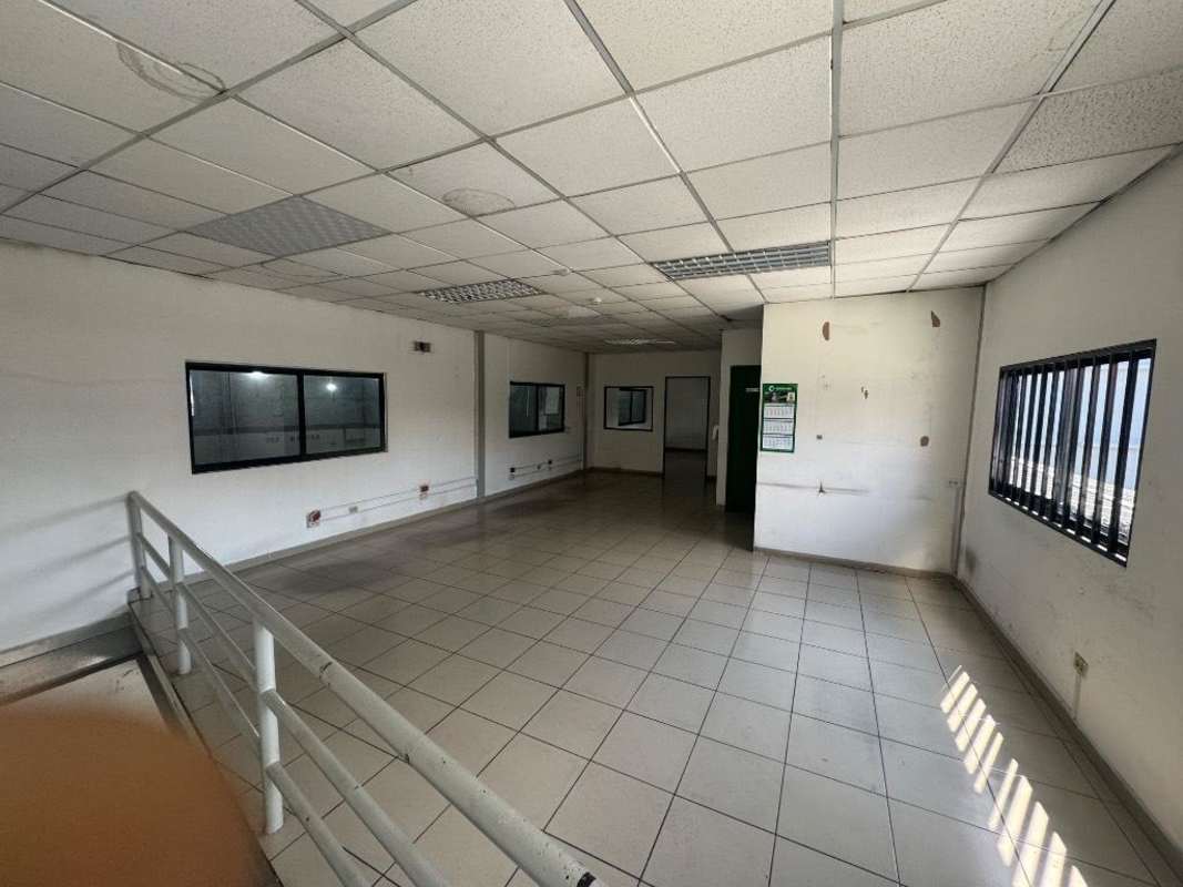 Empty tiled industrial office with fluorescent lights, barred windows in warehouse in Pueblo Nuevo Panama