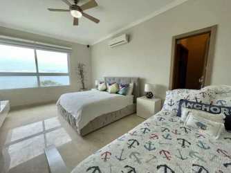 Bedroom with beds and large window with ocean views at Bijao Balboa 6 Panama