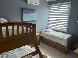 Bedroom with bunk bed, AC and large windows at beach condo in Bijao Panama