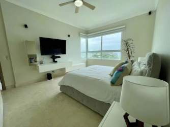 Bright bedroom with window, TV and neutral decor in Balboa 6 at Bijao Beach Residence