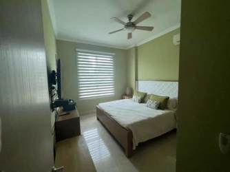 Spacious master bedroom with large window, ceiling fan and ocean view at Bijao Balboa 6 Panama