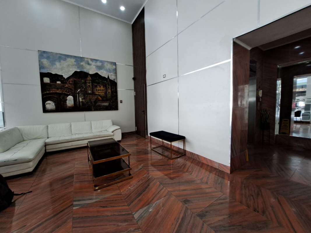 Spacious modern lobby with white sofas art glass table in PH Quartier Atlapa