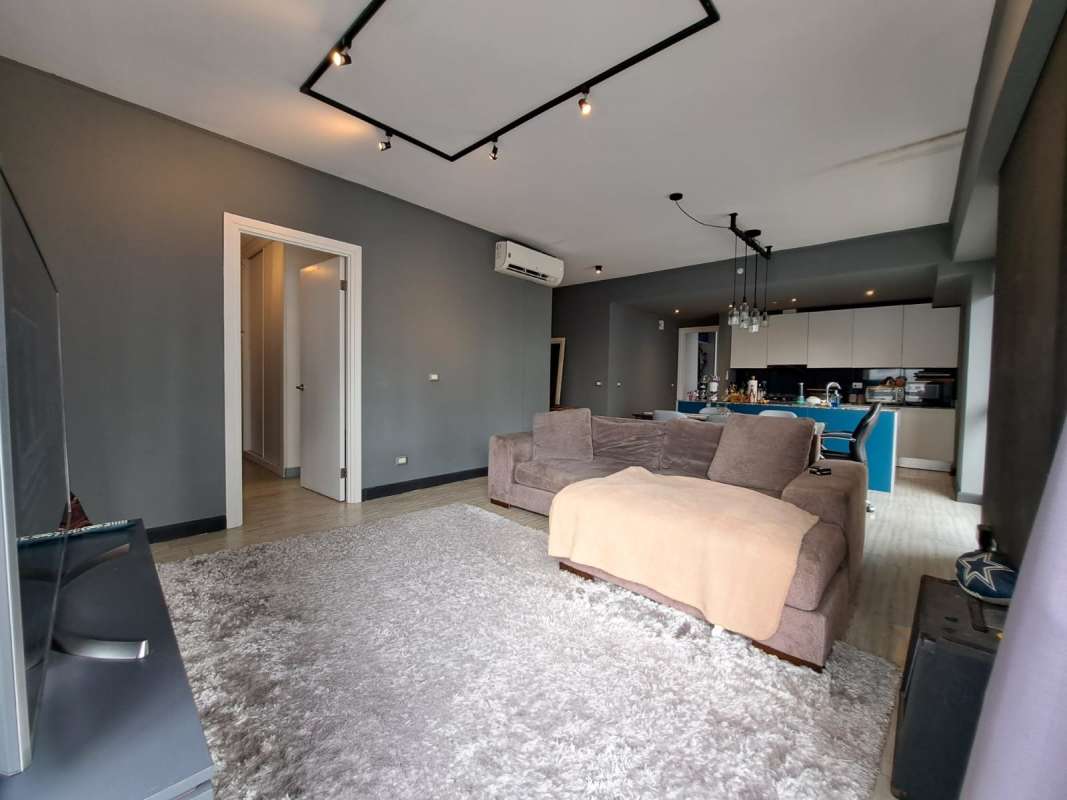 Open-plan living area with city view windows and sofa in PH Quartier Atlapa Panama City