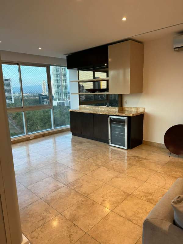 Modern kitchen with granite countertops, brown cabinetry and gas stove PH Titanium Costa del Este Panama City