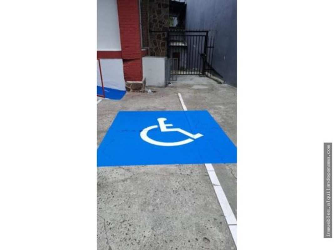 Blue-marked accessible parking adjacent to commercial building entrance on Calle 50 Bella Vista Panama