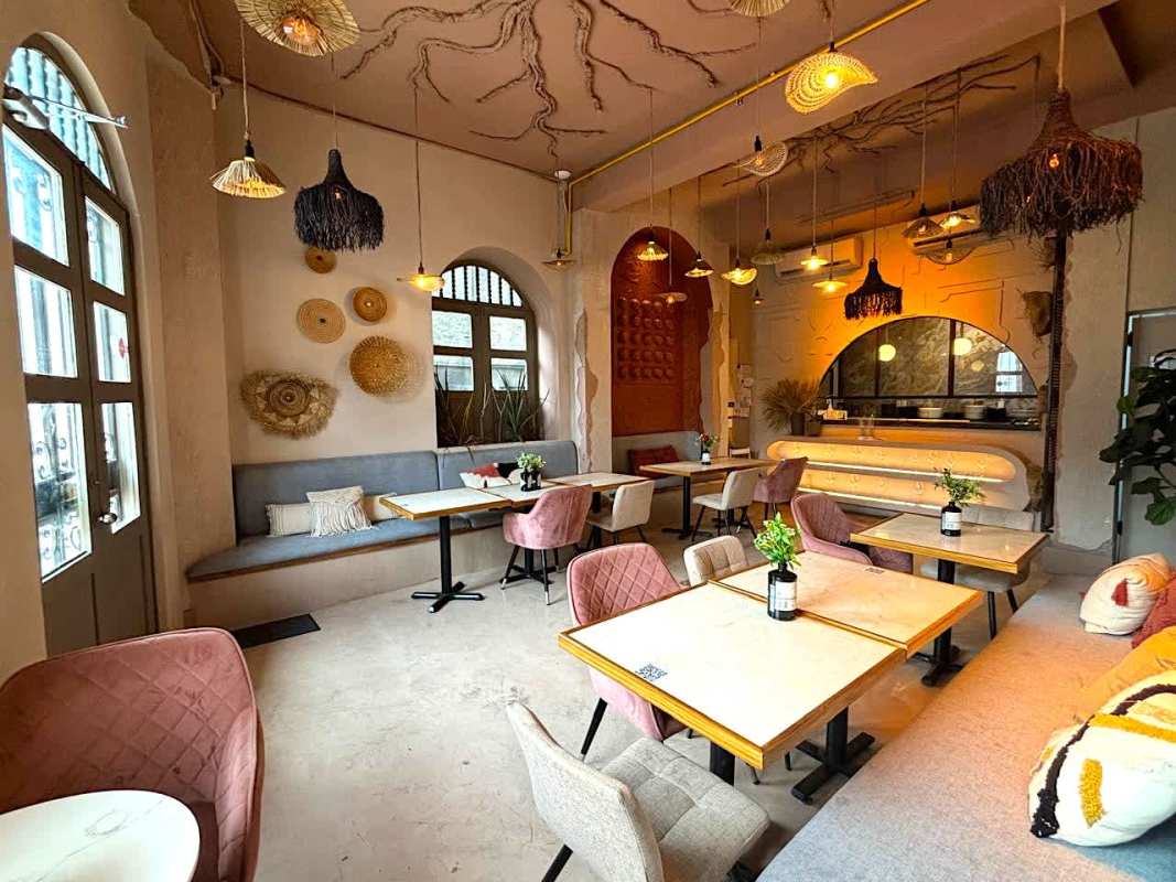Arched windows, pendant lights, wooden tables, cozy dining in Casco Viejo historic commercial building