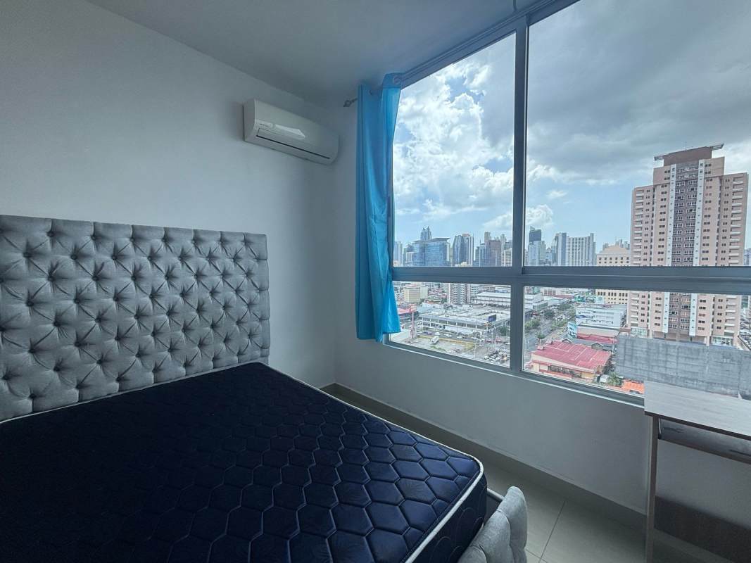 Minimalist bedroom with window showing city skyline at PH Rainbow Tower Panama