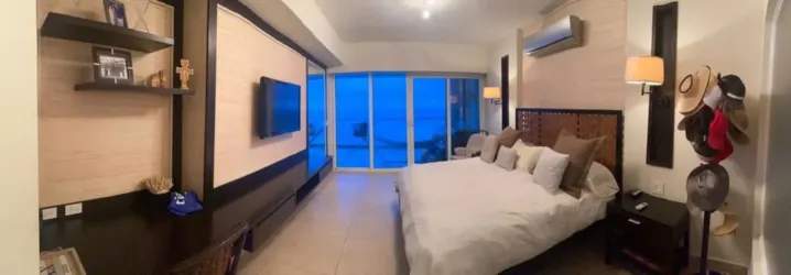 Elegant master bedroom with glass doors to the ocean, TV, and contemporary design Santa Clara Panama