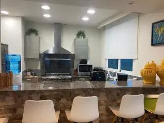 Modern kitchen with granite island, appliances, large oceanfront window in Santa Clara Sky Residences