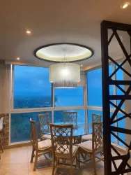 Dining room with large window overlooking Pacific ocean coastline in Santa Clara Sky Condominium