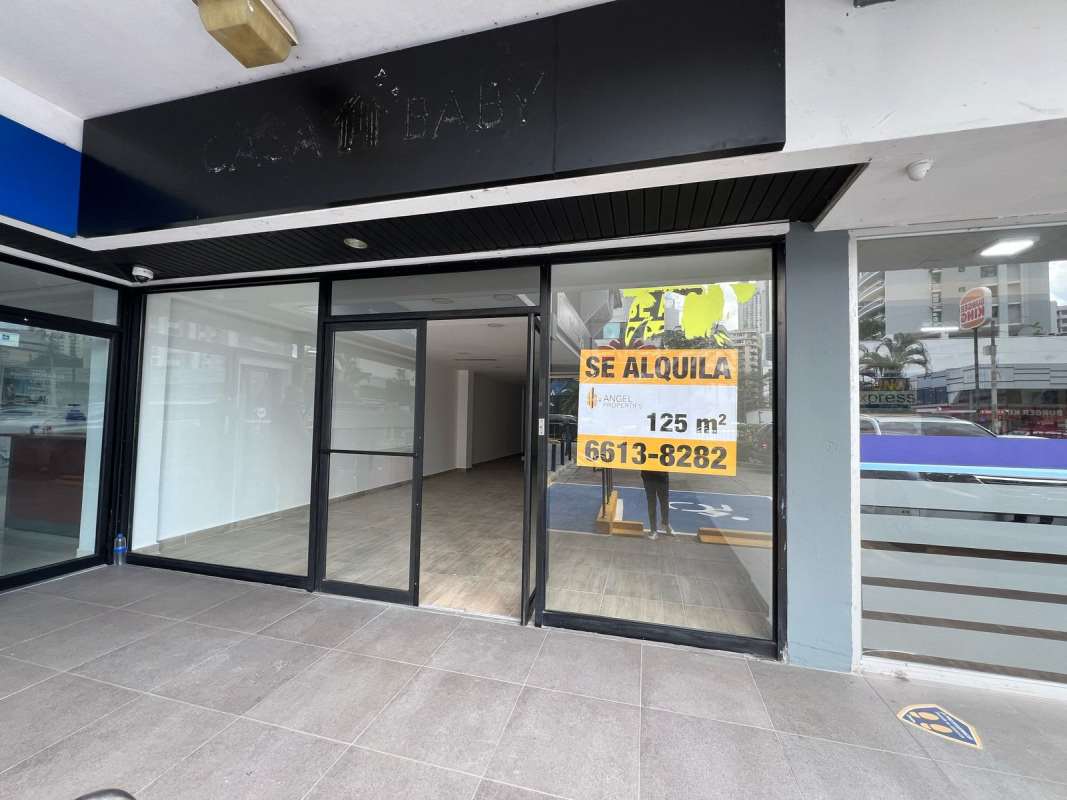 Basic commercial bathroom with white tile finish, toilet and sink in retail space Panama City