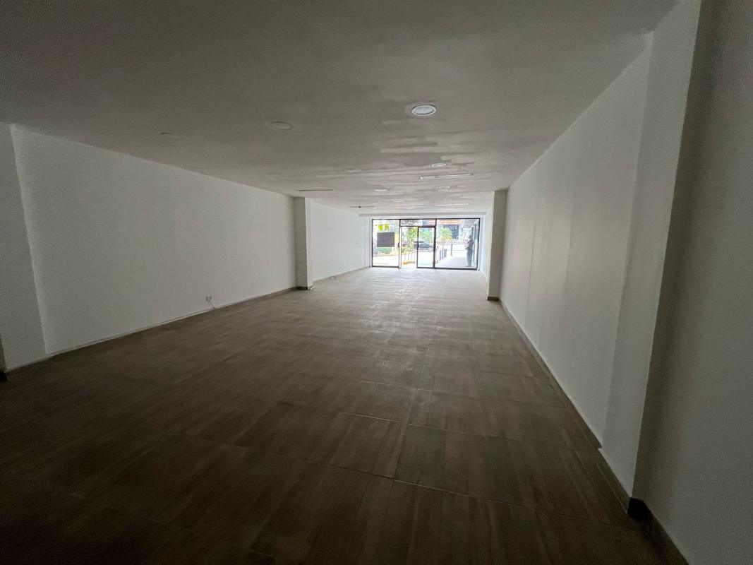 Commercial center exterior with parking spaces storefronts and high rise backdrop Panama City