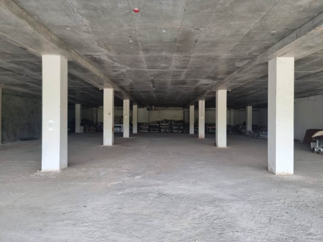 Spacious raw commercial warehouse interior with concrete floors and walls at Costa Sur shopping plaza