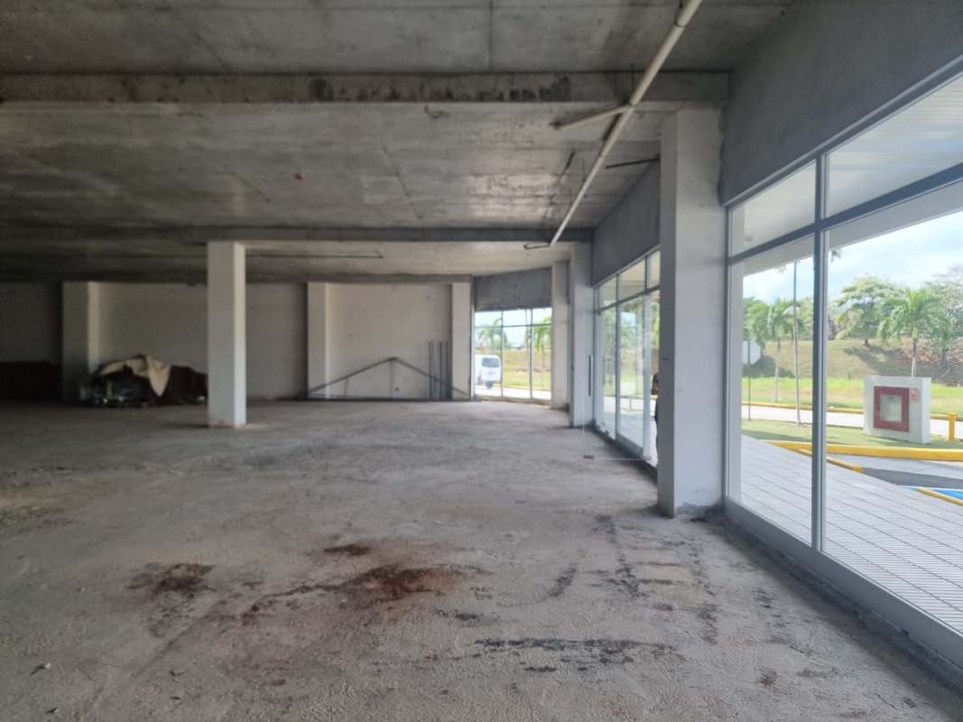 Spacious empty concrete interior retail unit with glass doors in Panama Costa Sur Shopping Mall