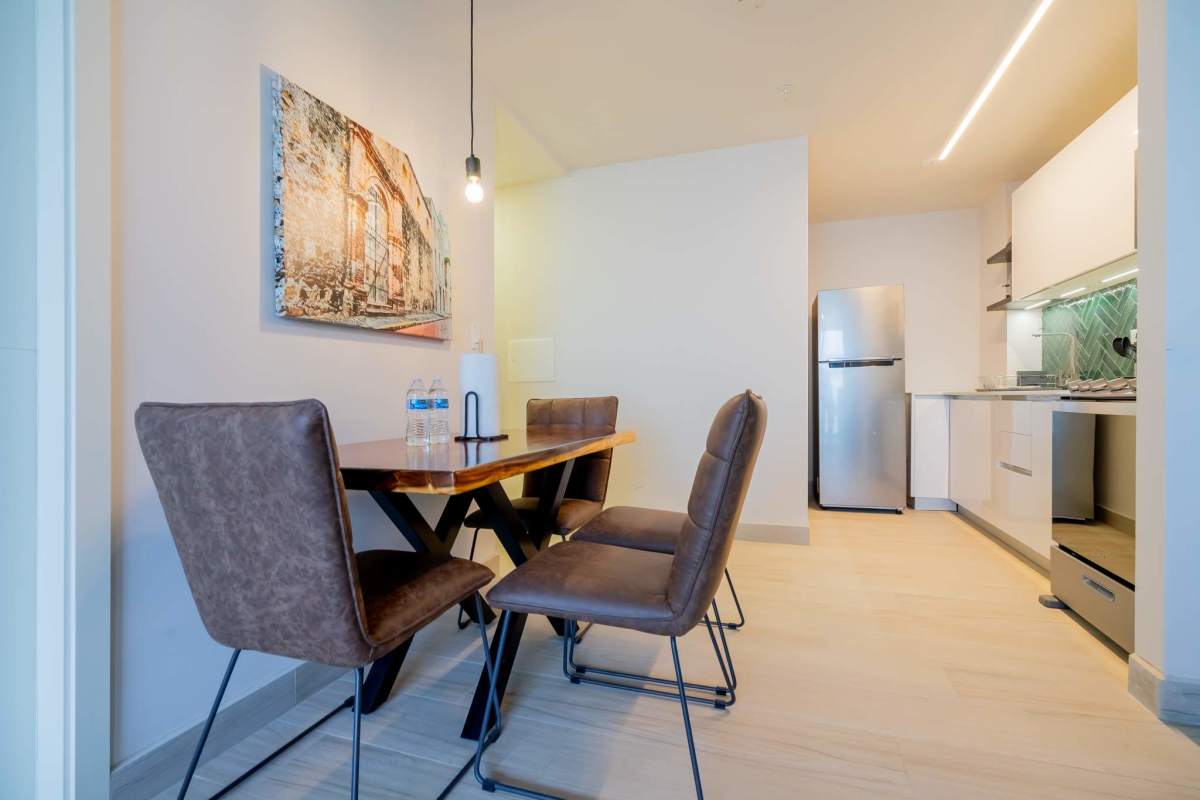 Dining table adjacent white cabinetry green tile kitchen Casa Lefevre Casco Viejo Panama